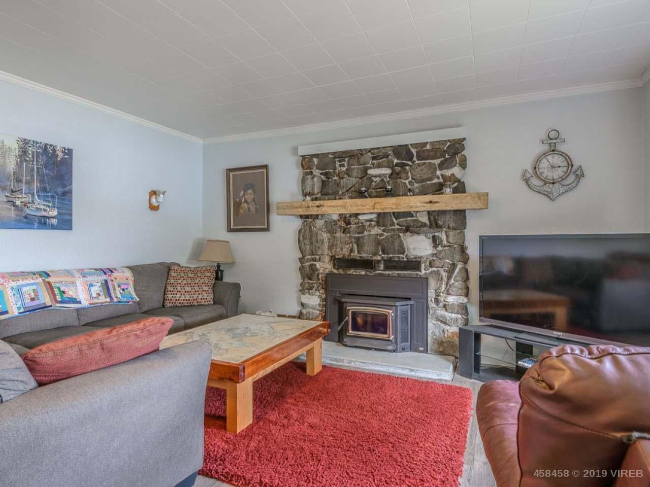 A living room with a fireplace , couch , table and television.