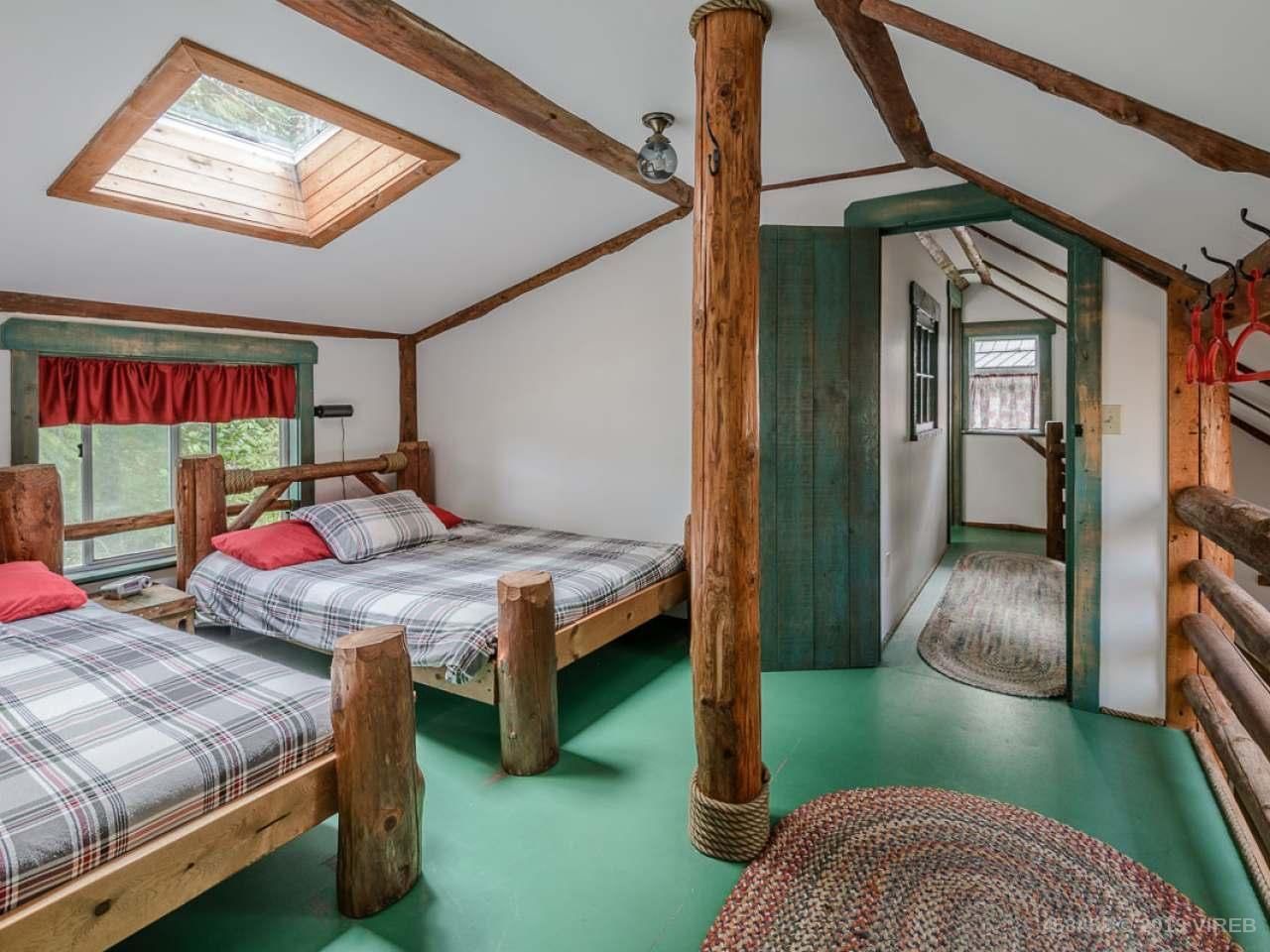 A bedroom with two beds and a skylight in the ceiling