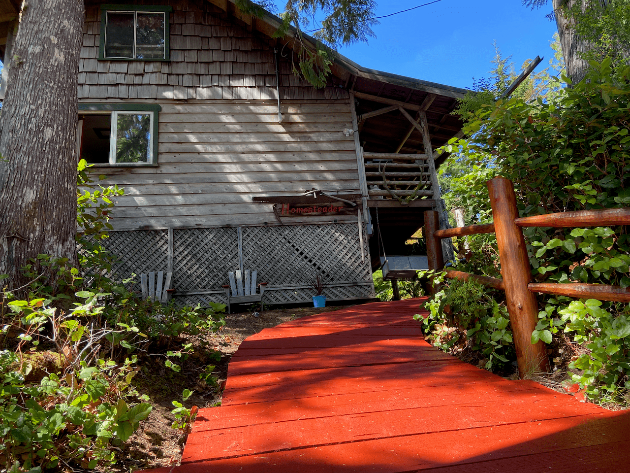 A wooden house with a red walkway leading to it