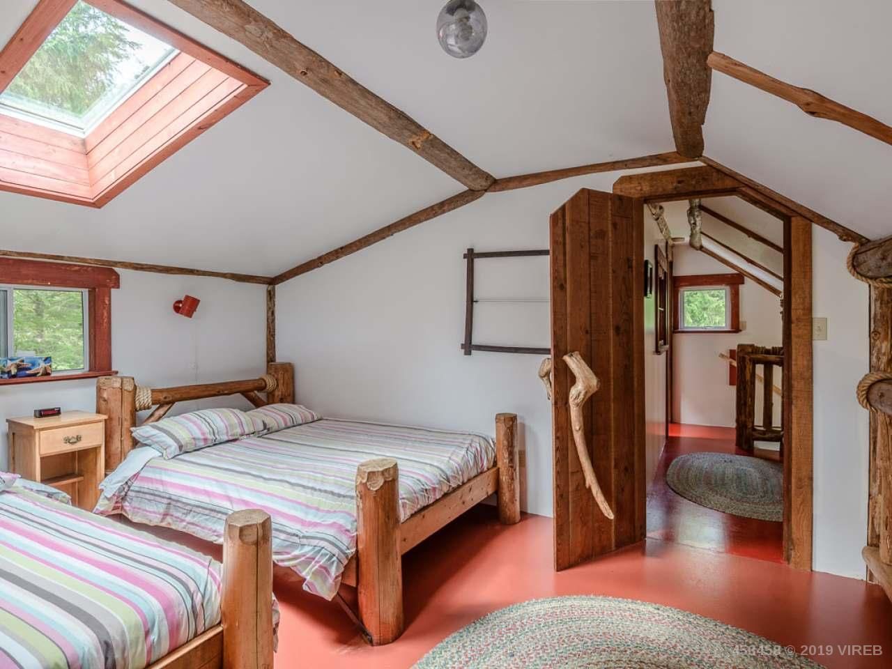 A bedroom with two beds and a skylight on the ceiling