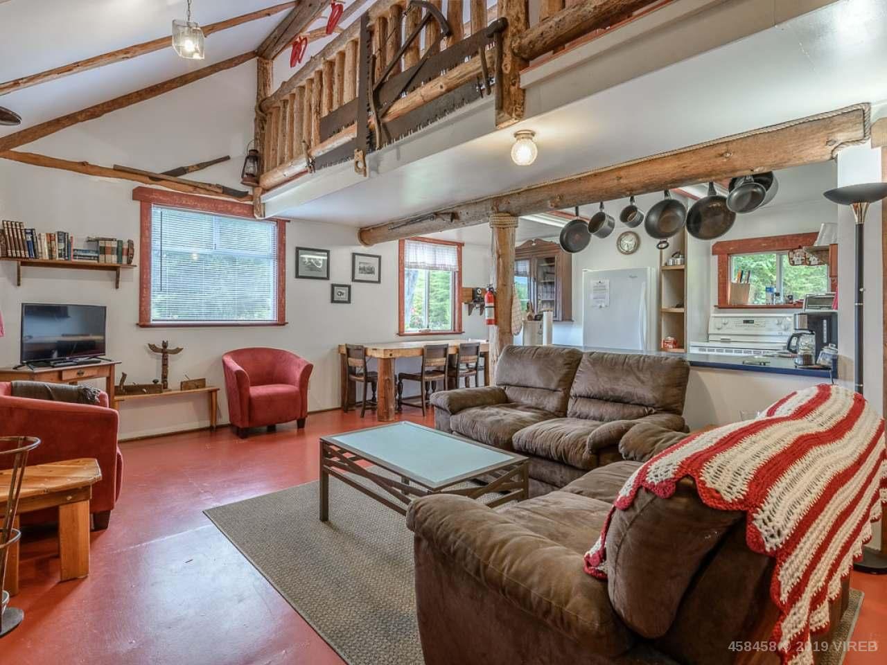 A living room with a couch , chairs , table and television.