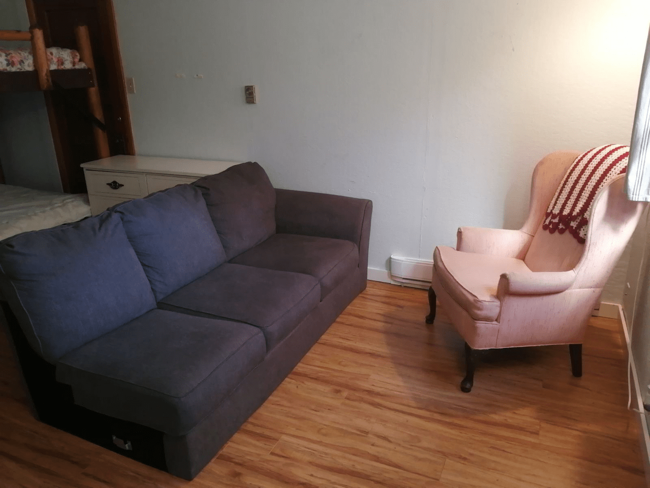 A living room with a couch and chair and a bunk bed