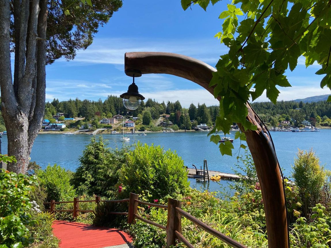 A wooden pole with a lamp on it is in front of a body of water