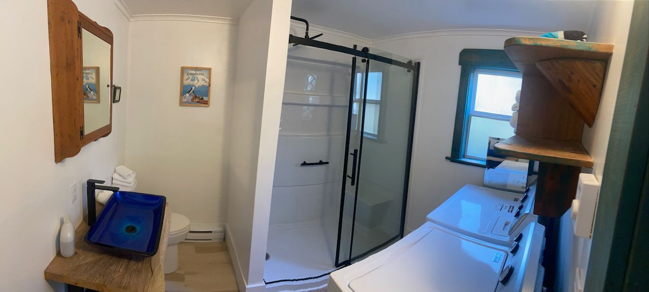 A bathroom with a washer and dryer and a shower.