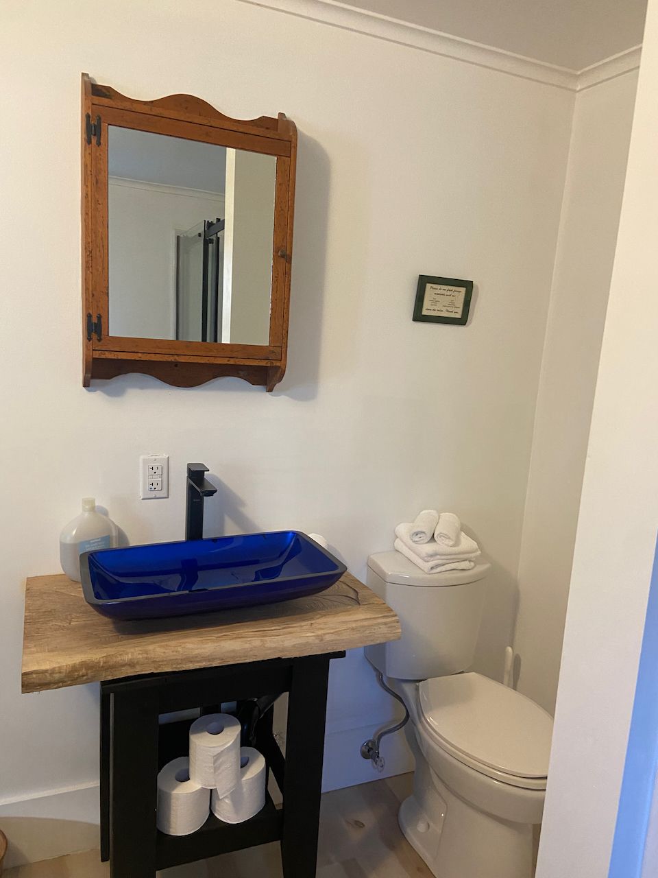 A bathroom with a blue sink and a toilet