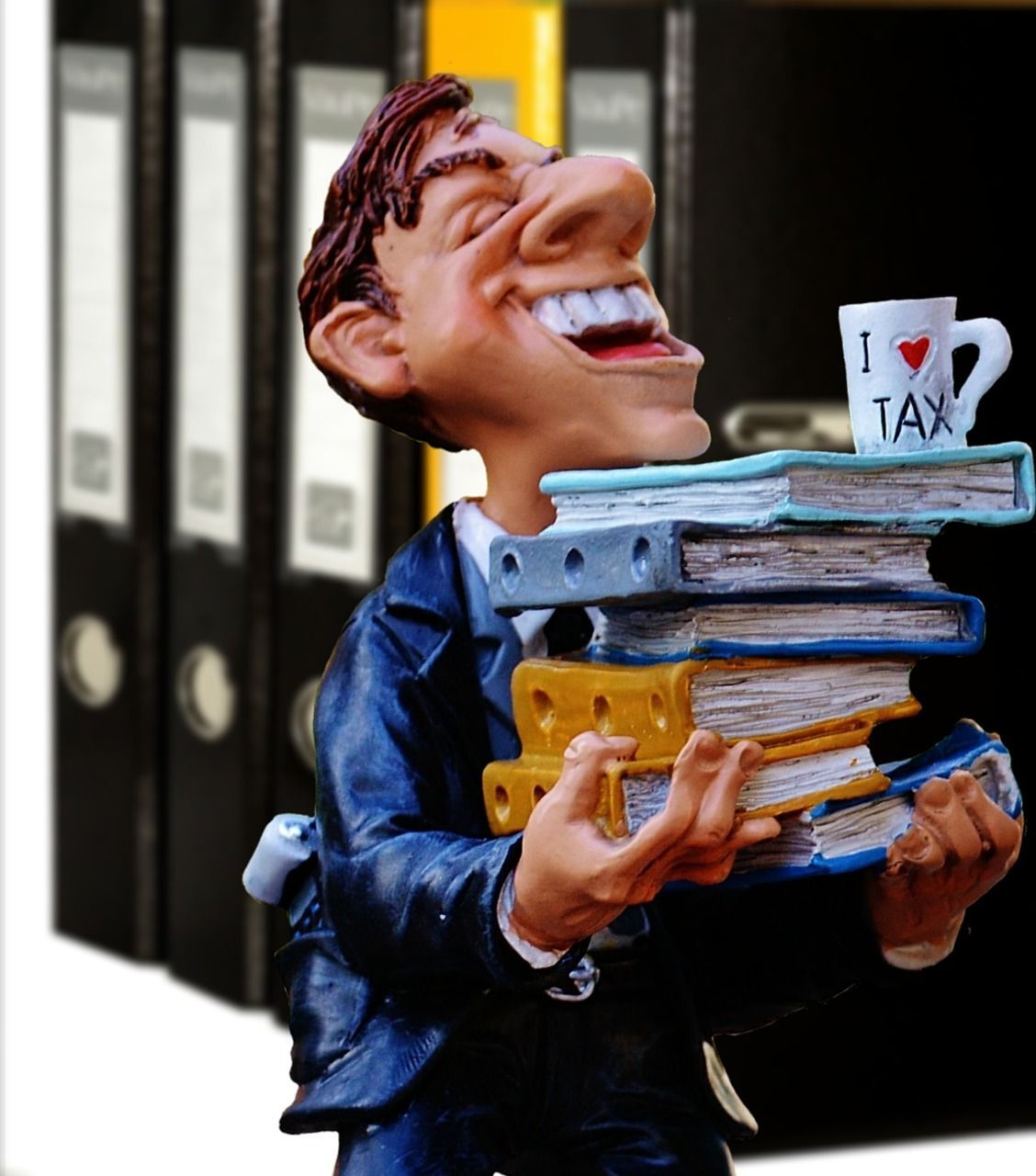 clay image holding stack of binders with cup on top says i love tax