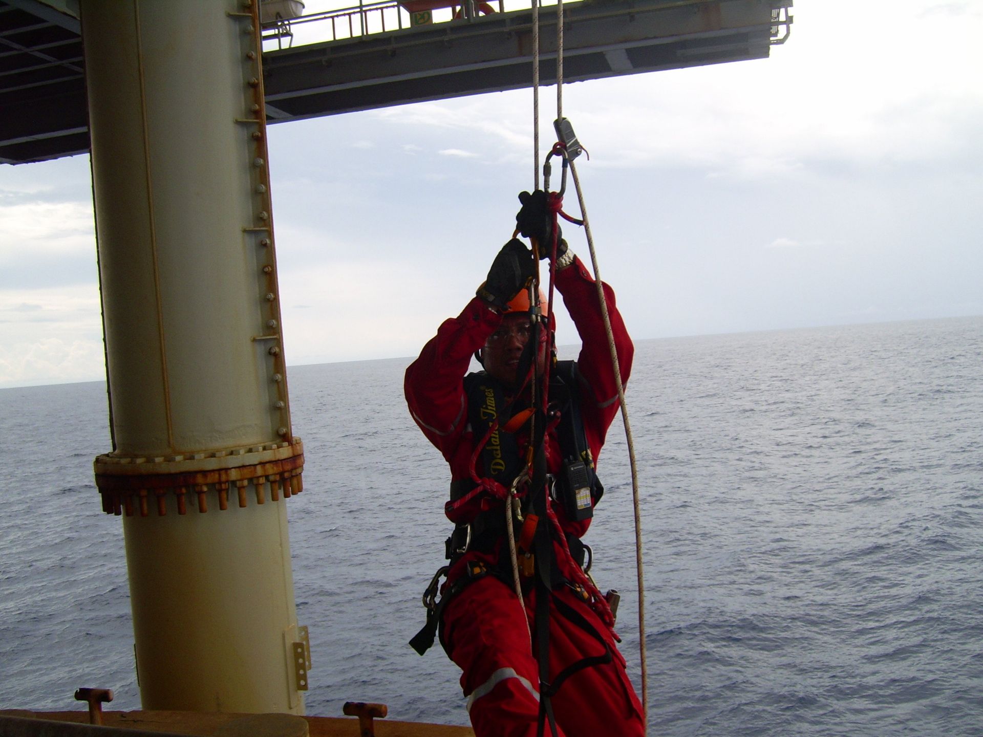 Men on red suit hanging for rope access