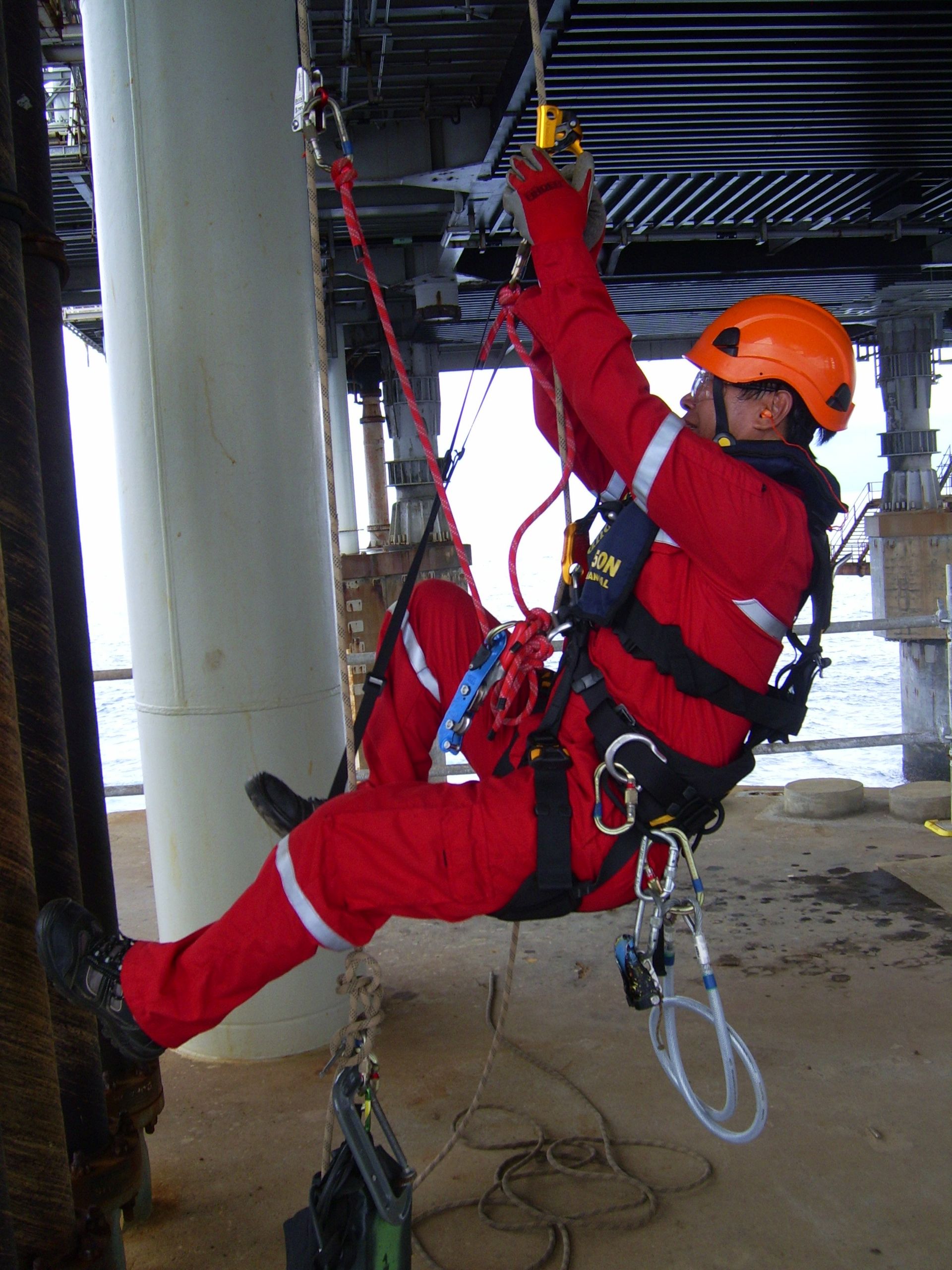inspection personnel in red suit and orange hard hat