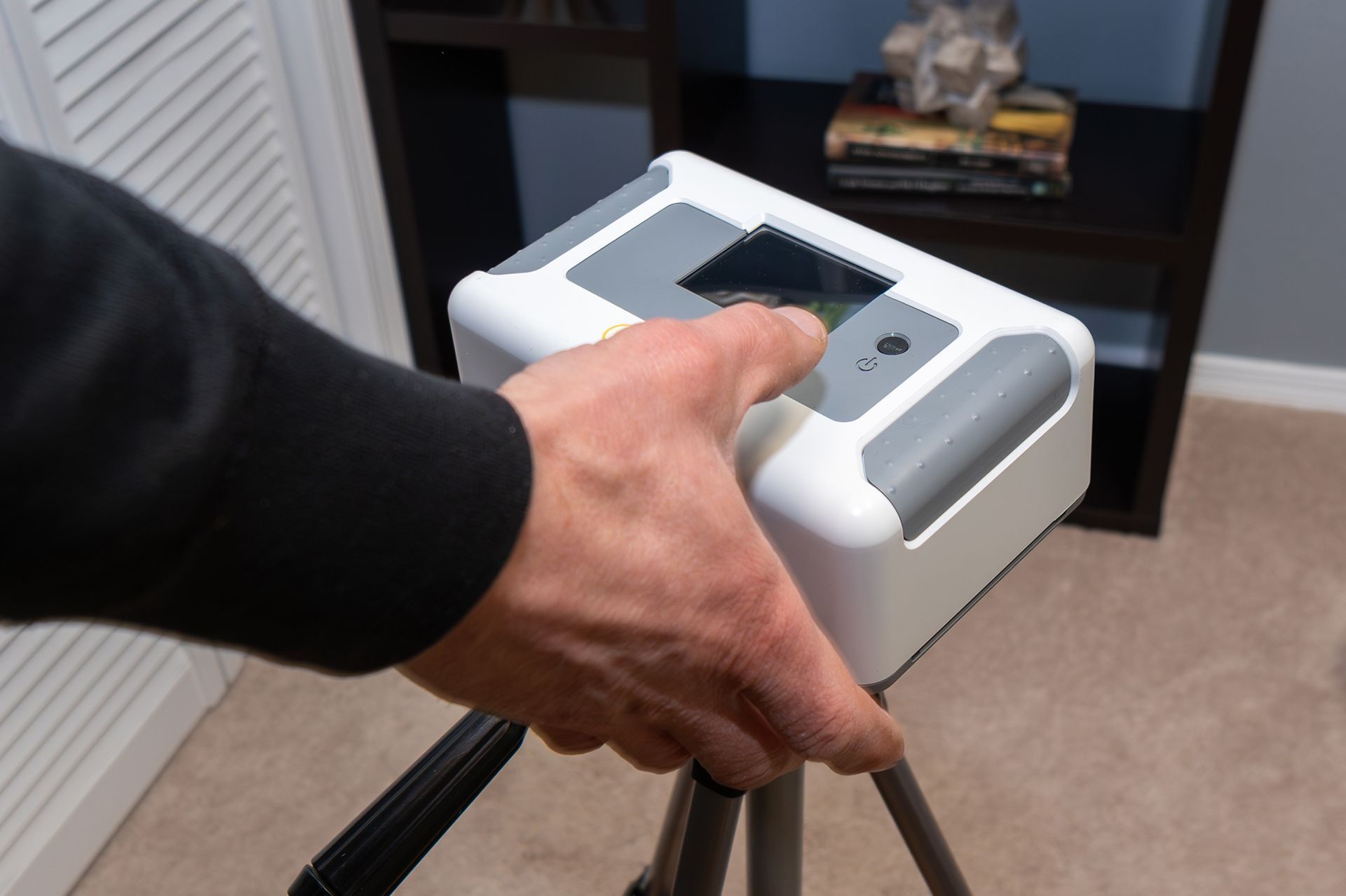 A person is pressing a button on a device on a tripod