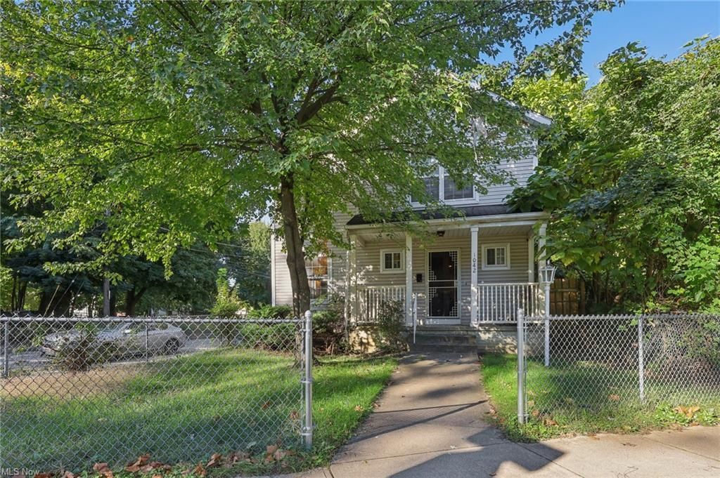 A dining room with a table and chairs and a wooden staircase.