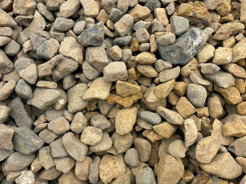 Pile of small tan and gray rocks and gravel filling the frame