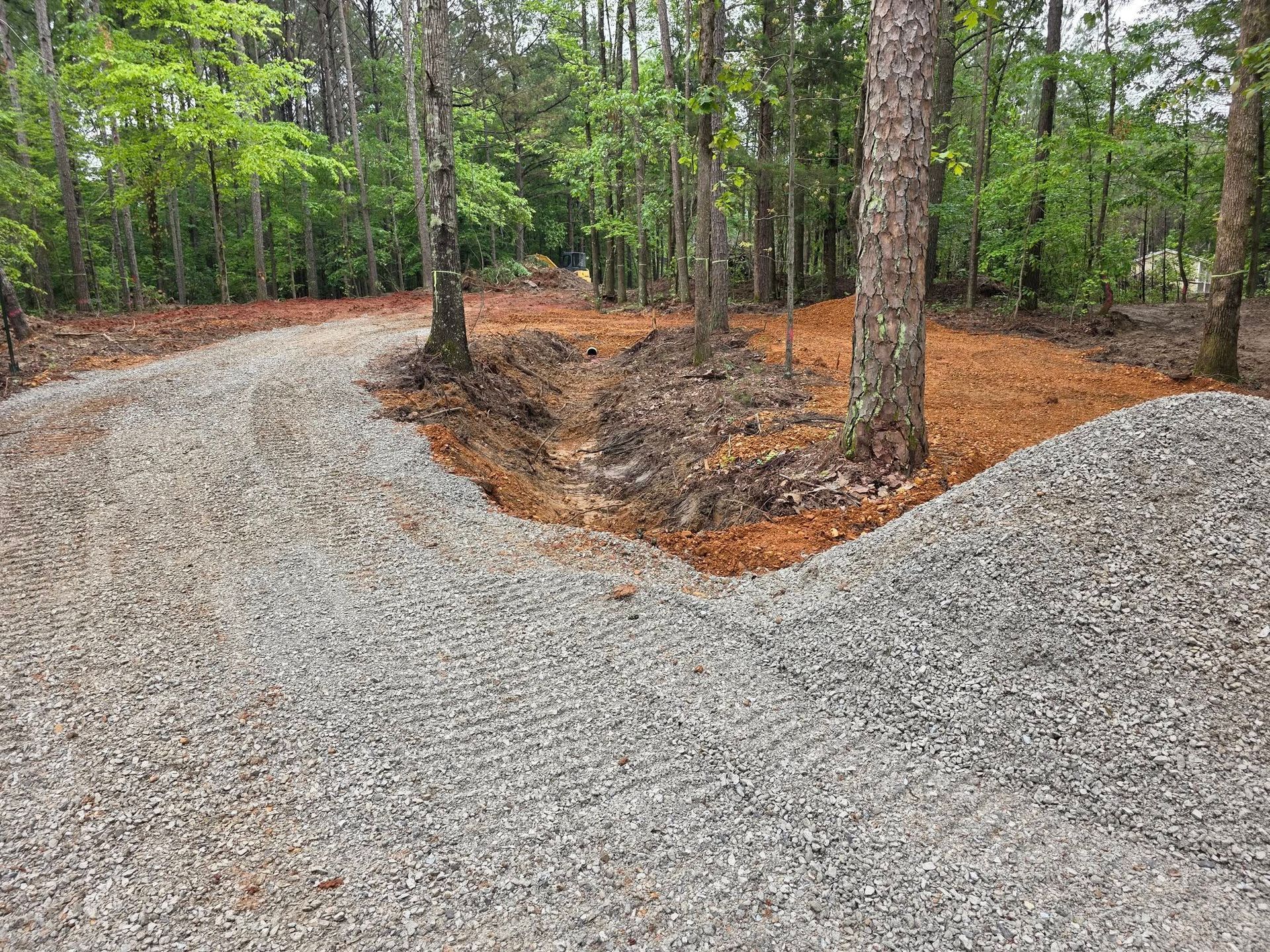 Garage with concrete driveway, brick columns, and water in the background.