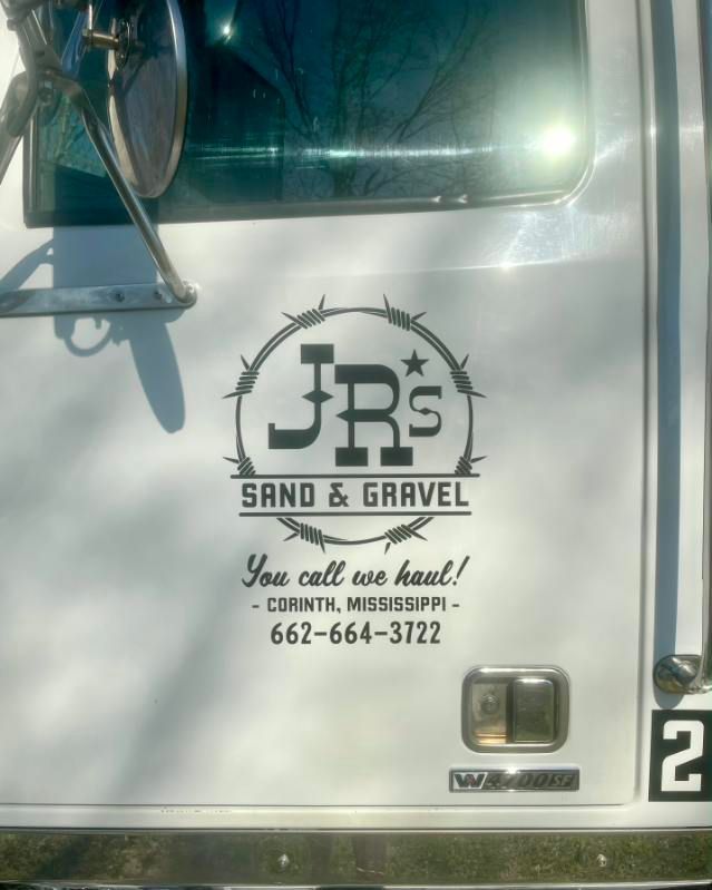 White truck door with JRS Sand & Gravel logo and phone number printed in black.