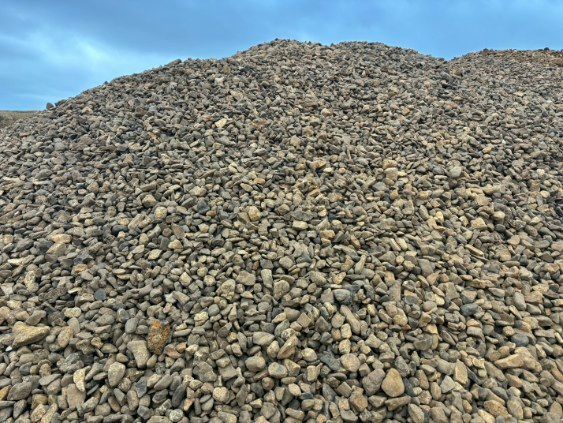 Large mound of gray rocks and gravel under a blue sky