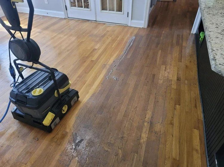 A machine is being used to clean a wooden floor