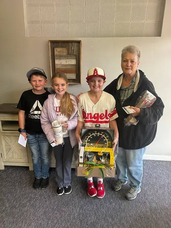 A group of children are standing next to each other in a room.