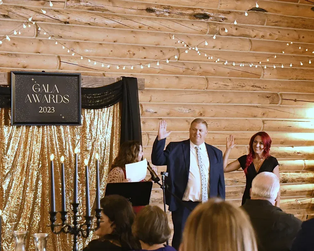 A man and woman are standing in front of a sign that says gala awards