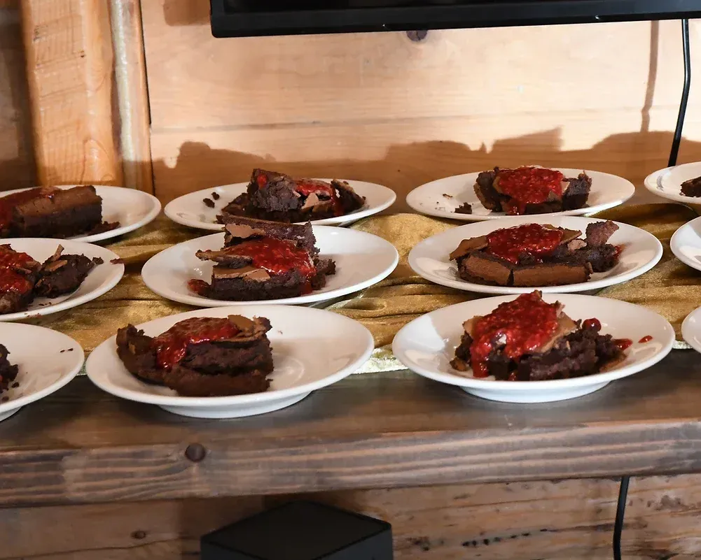 Plates of food on a table with a tv in the background