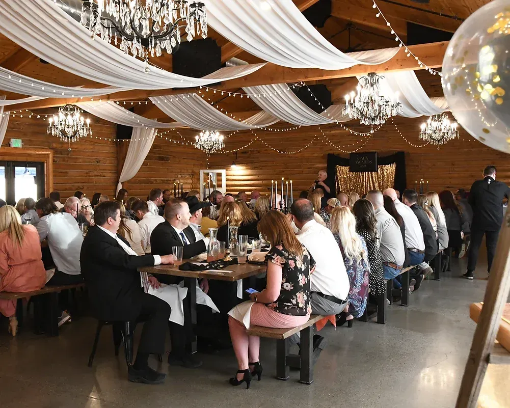 A large group of people are sitting at tables in a large room.