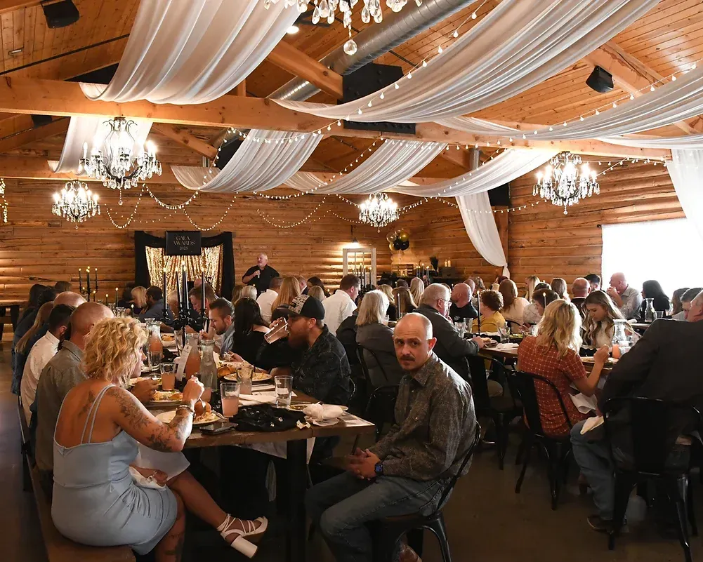 A large group of people are sitting at tables in a large room.