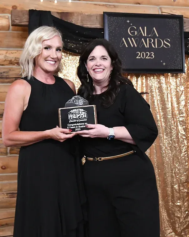 Two women are standing next to each other holding a plaque.