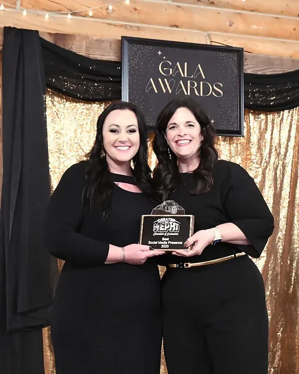 Two women are standing next to each other in front of a sign that says gala awards.