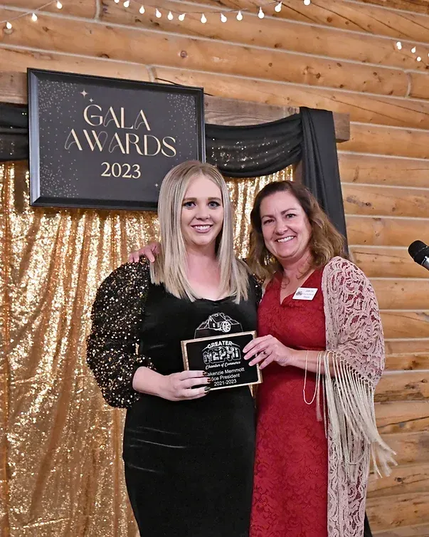 Two women are posing for a picture in front of a sign that says gala awards 2023.