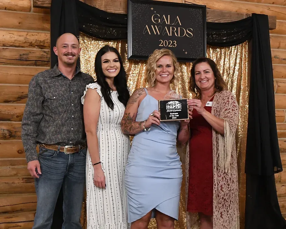 A group of people are posing for a picture in front of a gala awards sign.