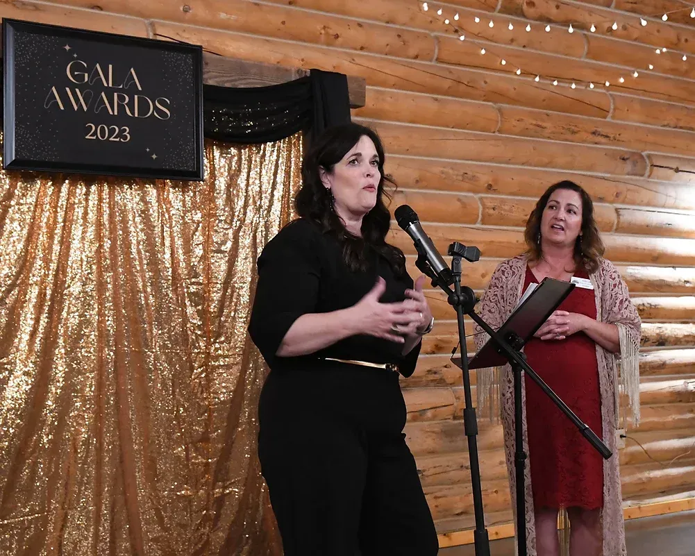 Two women are standing in front of a sign that says gala awards