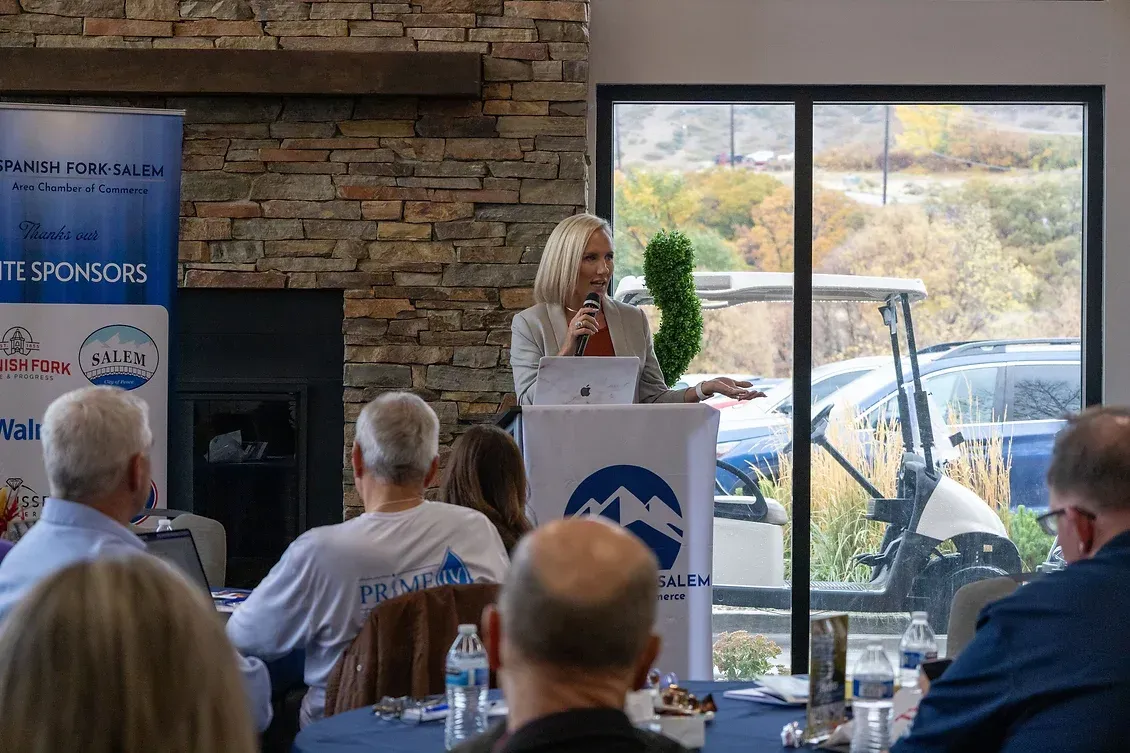A woman is standing at a podium giving a presentation to a group of people.