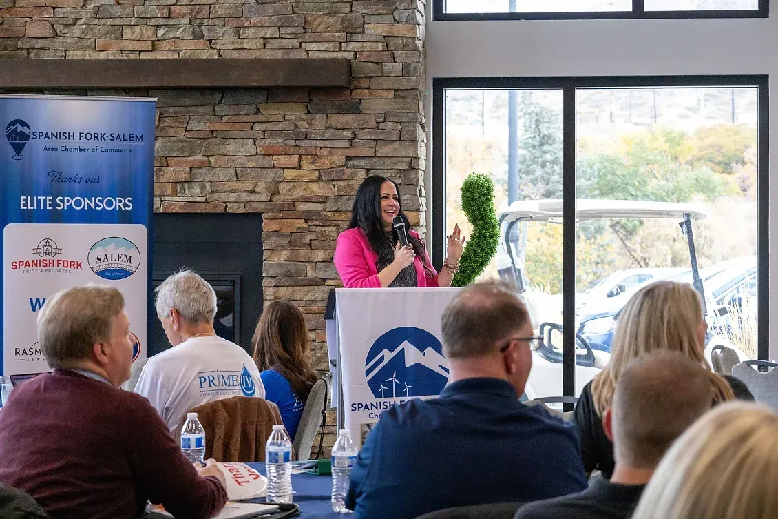 A woman is standing at a podium giving a speech to a group of people.