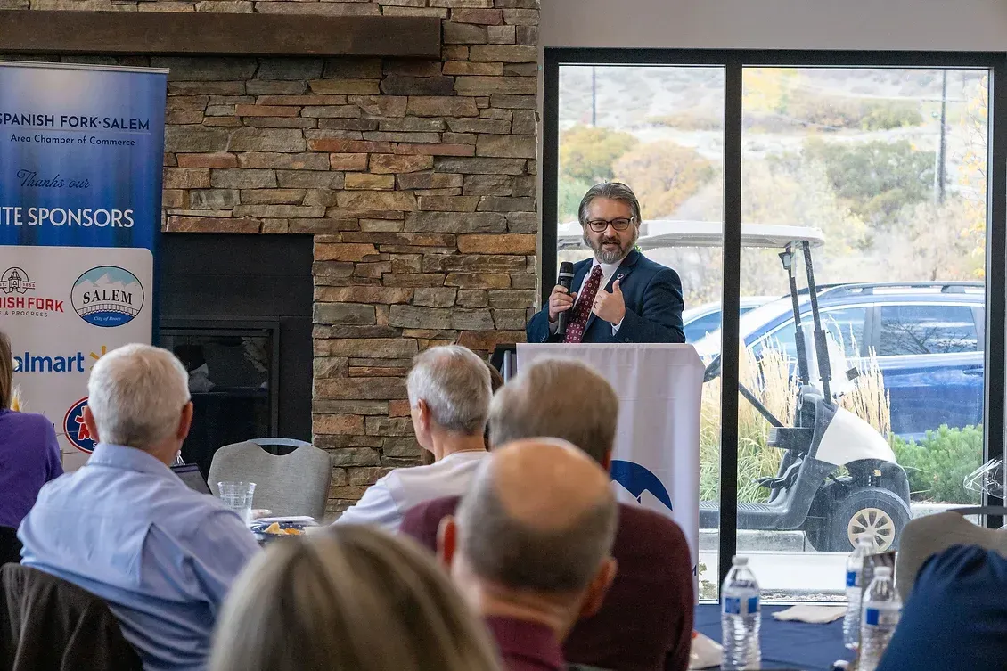 A man is standing at a podium giving a speech to a group of people.