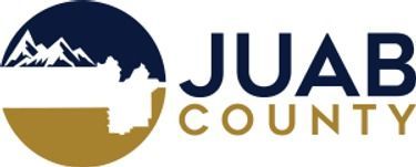 A logo for juab county with mountains in the background