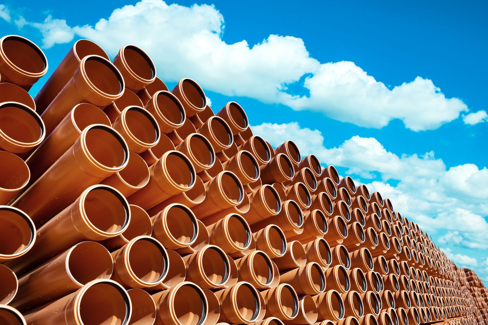 Una pila di tubi contro un cielo azzurro con nuvole