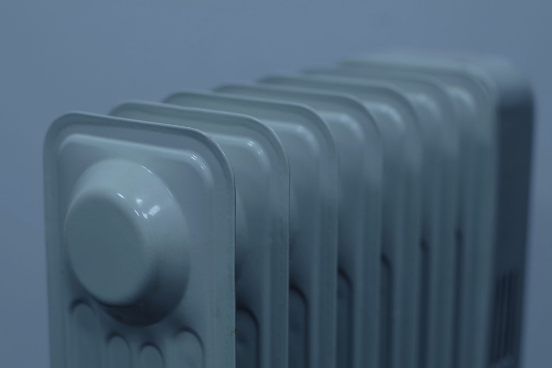 A close up of a radiator against a blue wall.