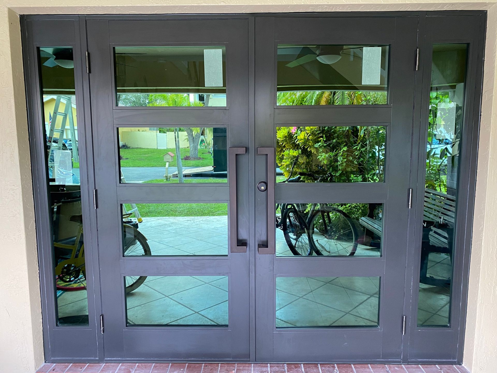 A door with a lot of glass and a bicycle parked in front of it