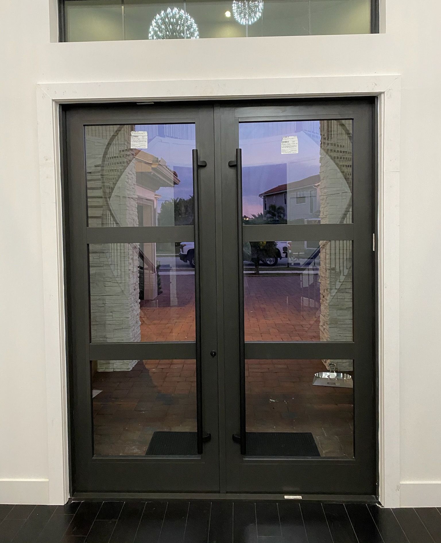 A door with a lot of glass is open in a room.