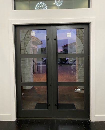 A door with a lot of glass is open in a room.