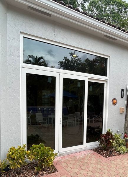 A house with a large window and sliding glass doors.