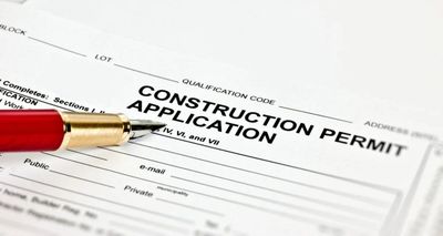 A pen is sitting on top of a construction permit application.