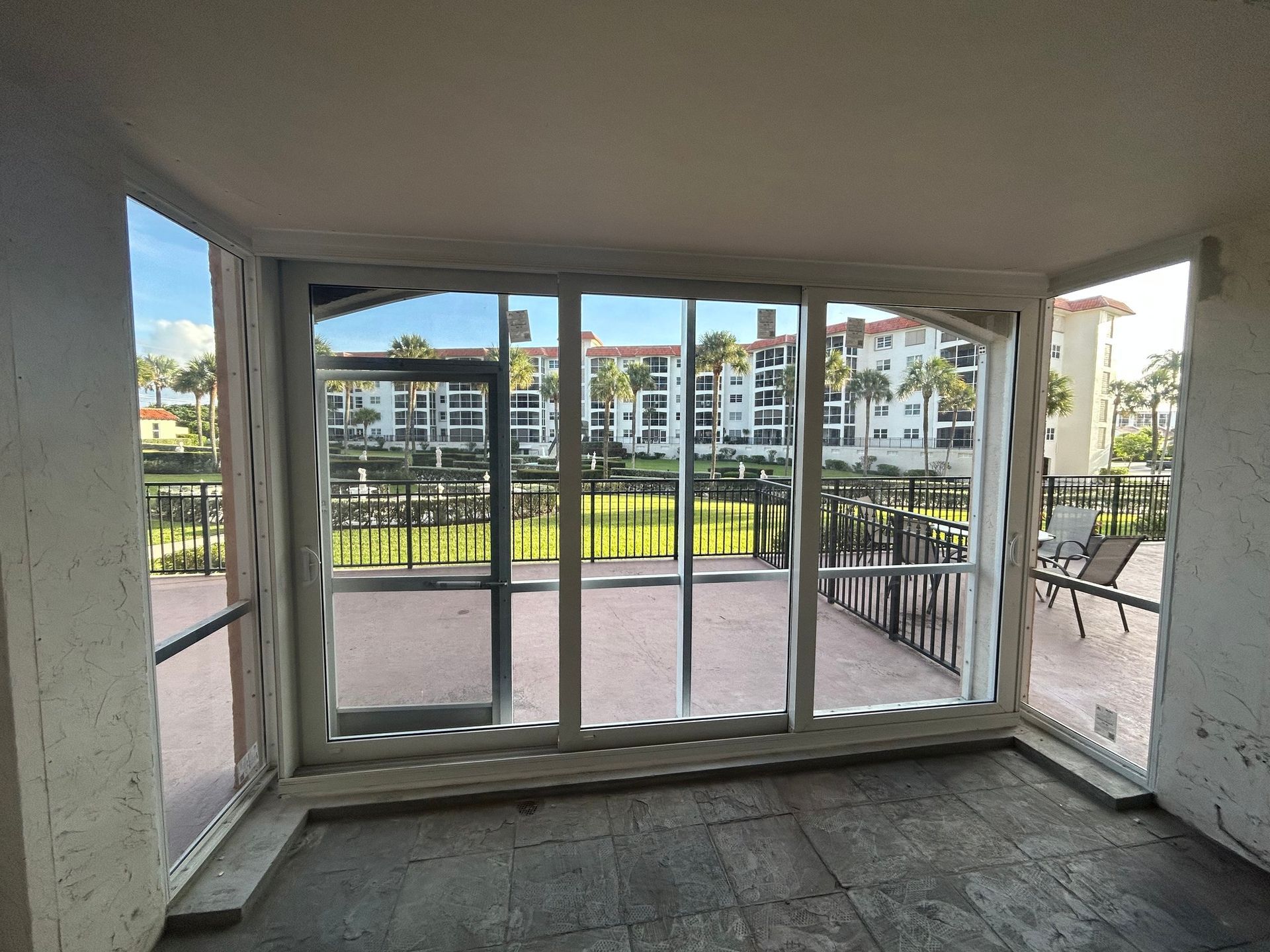 An empty room with a lot of windows and a balcony.