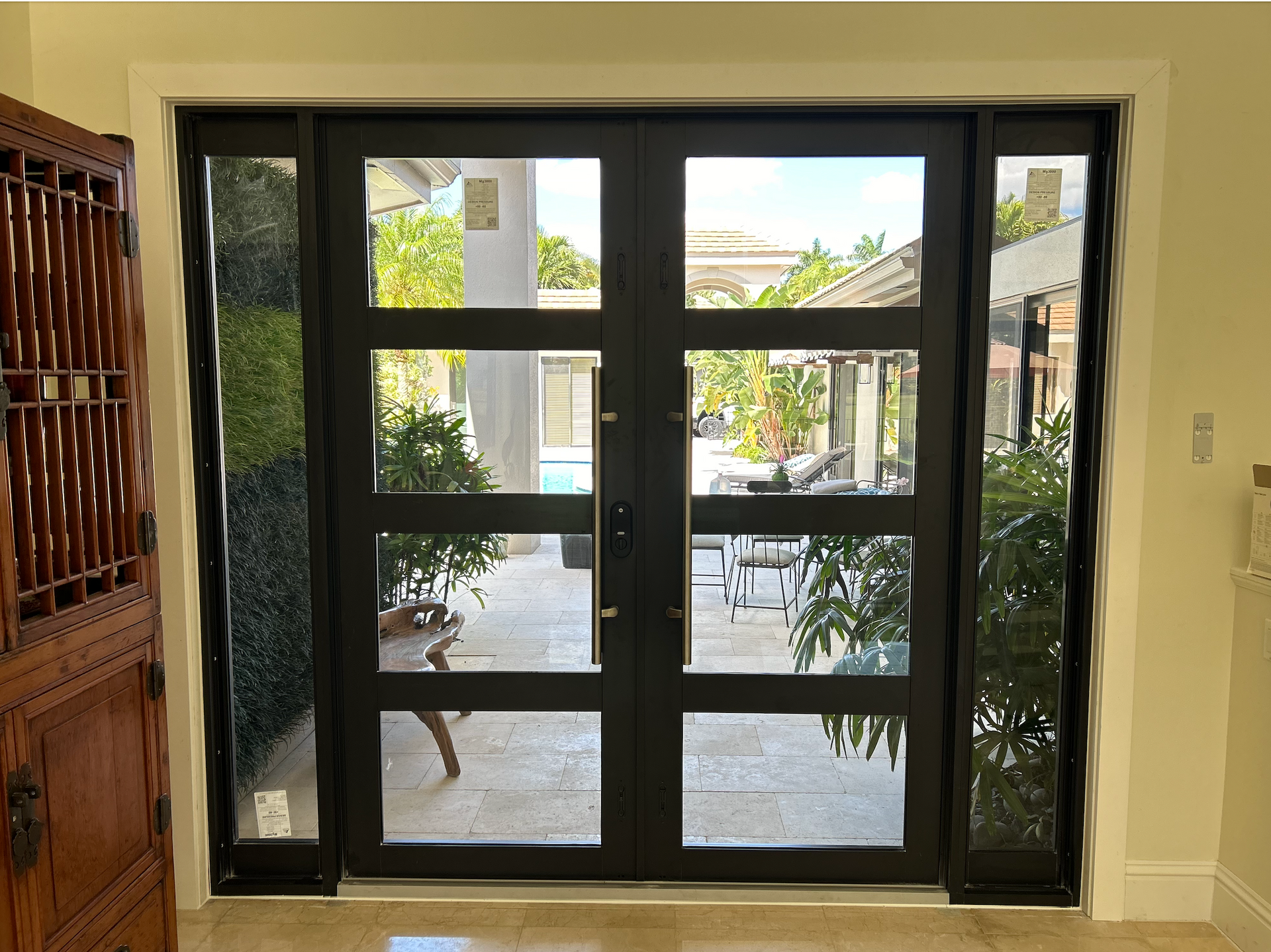 A door with a lot of windows is open to a patio.