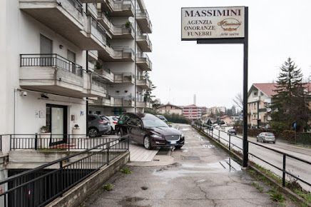 Casa funebre con carro funebre parcheggiato all'esterno. 