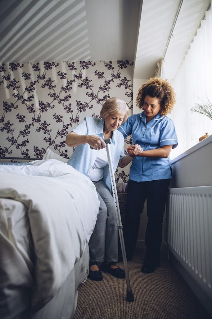 Elderly person being assisted by care facility staff member
