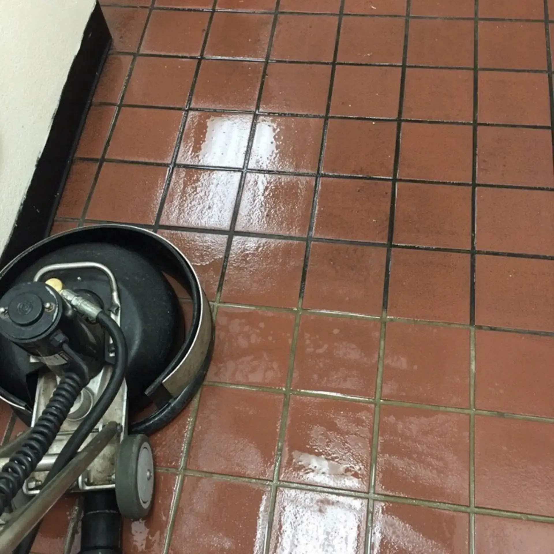 A tile floor is being cleaned with a machine