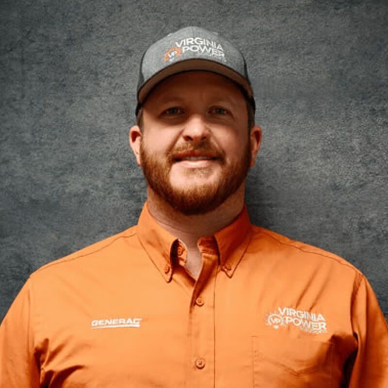 Man wearing a Virginia Power cap and orange work shirt, smiling. Gray background.