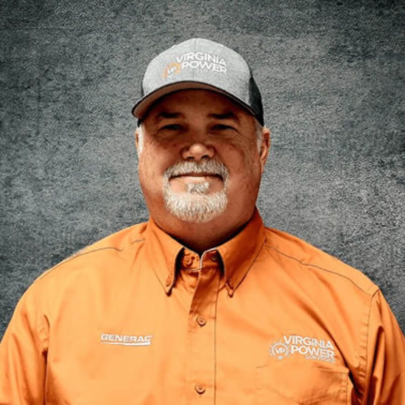 Man in orange Virginia Power shirt and hat with grey backdrop.