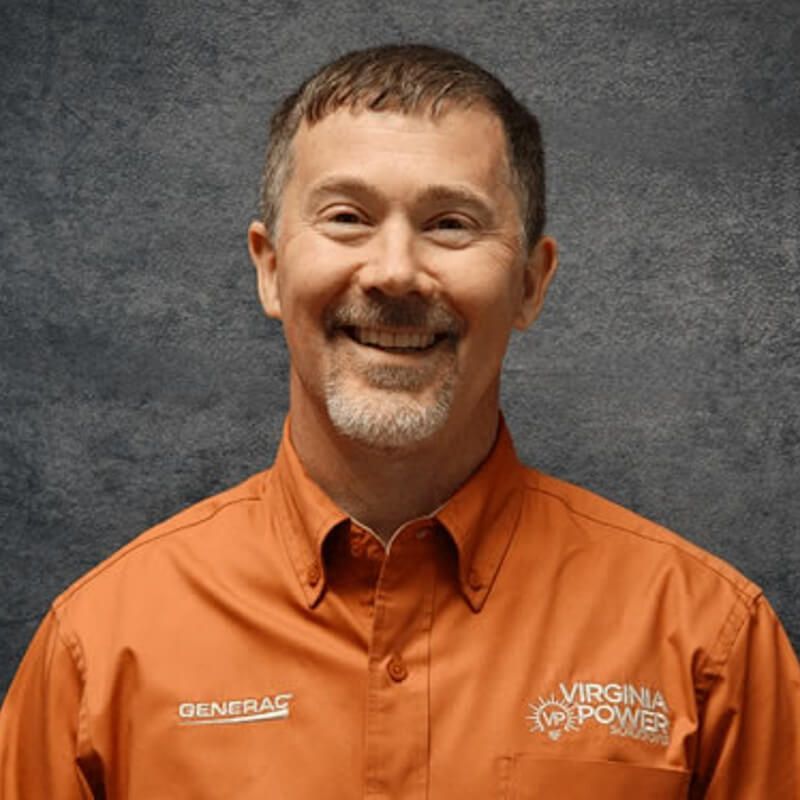 Man in orange work shirt smiling, Virginia Power logo visible.