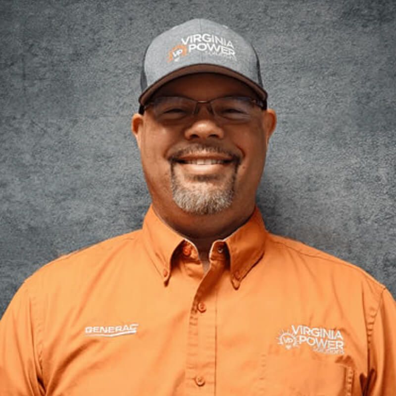 Man wearing glasses, orange shirt, and a hat with