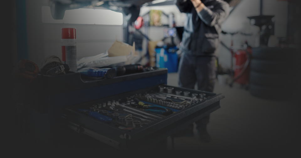 Mechanic working in a garage, tools in a toolbox in the foreground. | Roper Mountain Auto Care